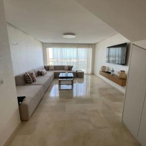 塔哈佐特Taghazout Paradise - Duplex Confort - Vue mer piscine - Agadir的配有沙发和桌子的大客厅