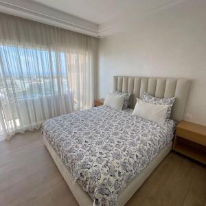 塔哈佐特Taghazout Paradise - Duplex Confort - Vue mer piscine - Agadir的一间带大床和大窗户的卧室