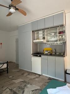 a kitchen with gray cabinets and a ceiling fan at Villa Katia in Asprovalta