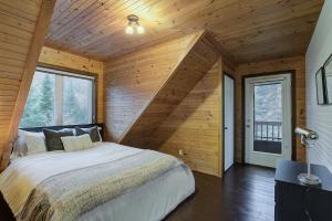 a bedroom with a large bed in a room with wooden walls at Chalet Le Montcalm in Saint Adolphe D'Howard