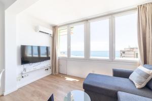 a living room with a couch and a tv and windows at Trendy Homes Paradise in Aguadulce