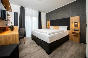 ein Hotelzimmer mit Bett und Schreibtisch in der Unterkunft Hotel am Park Bad Driburg in Bad Driburg