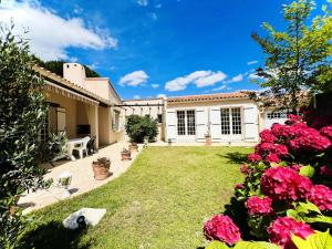 Villa Tournesol - Villa idéal pour les familles Quartier résidentiel MAE-5271 في لا غراند موت: حديقة بها زهور وردية ومنزل