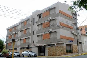 un edificio con coches estacionados frente a él en Hotel Giordano Centro, en São João da Boa Vista