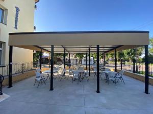 a pavilion with tables and chairs on a patio at Casa Andreea in Eforie Sud