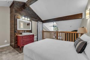 a bedroom with a bed and a sink and a mirror at 2BD Condo with Ski Run Views and Hot Tub Access in Park City