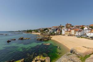 a view of a beach with houses and the ocean at Piso A Pie de Playa - A Corna in San Pedro