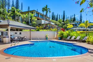 a swimming pool in front of a house at Kapalua Golf Villa 20V 1 in Kahana