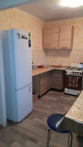 IzyumにあるTwo-Bedroom Apartment Pokrovskaya, 48のキッチン(白い冷蔵庫、木製キャビネット付)
