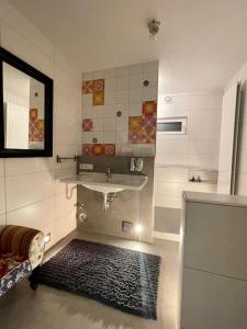 a bathroom with a sink and a mirror and a rug at Erholung im Main-Tauber-Kreis in Niederstetten +38 photos