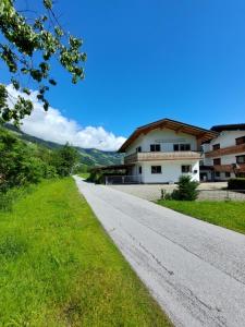 an empty road in front of a building at Landhaus Irena - Familienfreundliches Ferienhaus an der Zillerpromenade mit Bergblick in Ramsau im Zillertal