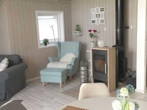 a living room with a blue chair and a tv at Holiday home Dan Huus Marie in Großenbrode