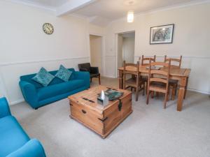 ein Wohnzimmer mit einem Tisch und einem blauen Sofa in der Unterkunft White Swan Cottage in Alnwick