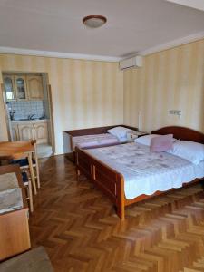 a bedroom with a large bed and a wooden floor at Studio Danica in Banjol