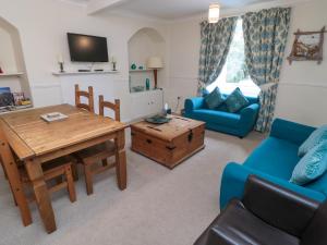 ein Wohnzimmer mit einem Tisch und einem blauen Sofa in der Unterkunft White Swan Cottage in Alnwick + 23 Fotos