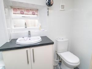 ein weißes Badezimmer mit Toilette und Waschbecken in der Unterkunft White Swan Cottage in Alnwick