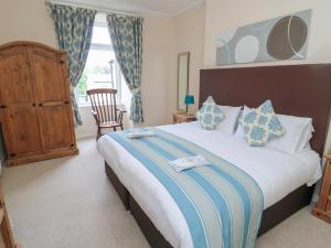 ein Schlafzimmer mit einem großen Bett mit einem hölzernen Kopfteil in der Unterkunft White Swan Cottage in Alnwick