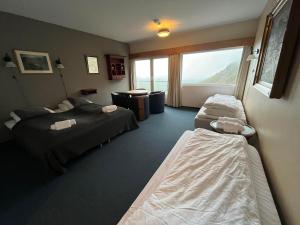 ein Hotelzimmer mit zwei Betten und einem Fenster in der Unterkunft Hotel Videseter in Stryn