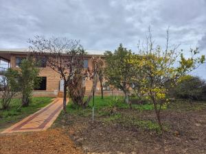 a brick building with a sidewalk in front of trees at Turquoise Coast Lodge in Jurien Bay