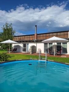 ein großes Schwimmbad vor einem Haus in der Unterkunft Ferienwohnungen zum Dubener Kuckuck in Luckau