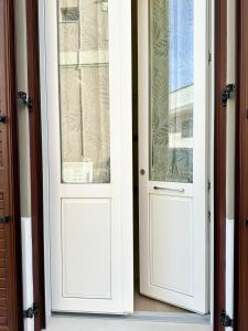 a pair of white doors on a house at La Dimora del Corso appartamento in Campi Salentina