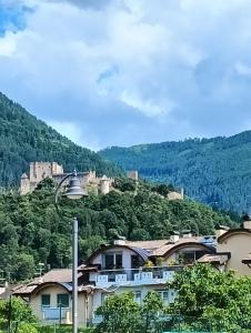 a view of a town with a castle on a hill at VINC & TROTTI HOUSE OF DÈJÀ-VU in Pergine Valsugana +21 photos