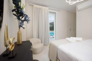 a bedroom with a bed and a vase with a plant at Villa Vilielmini Paxos in Gaios