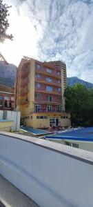 a large building with a pool in front of it at Hotel International in Băile Herculane