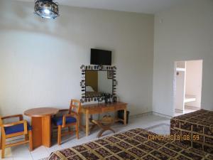 a room with a table and chairs and a desk at HOTEL MISION SANTA MARIA in San Quintín