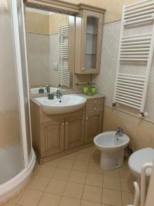 a bathroom with a sink and a toilet and a mirror at Appartamento Vista mare con Piscina Cala di Sole in Imperia