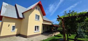 a large yellow house with a red roof at La mama Miha in Agigea