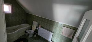 a bathroom with a toilet and a tub and a sink at La mama Miha in Agigea