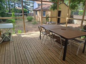 a wooden table and chairs on a wooden deck at Sous les tilleuls in Saint-Brevin-les-Pins