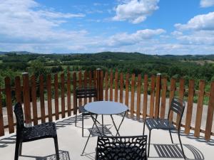 a table and chairs on a patio with a view at Maison La Chapelle Bellevue in Saint-Solve