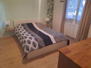 a bed in a room with a wooden floor at Sous les tilleuls in Saint-Brevin-les-Pins