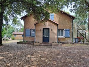 a brick house with a blue door on it at Sous les tilleuls in Saint-Brevin-les-Pins