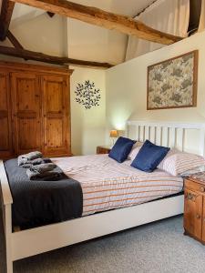 a bedroom with a large bed with blue pillows at Laurel cottage Melplash in Netherbury