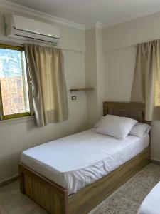 a bedroom with a large bed with white sheets and a window at Blue Bay Village- Private Chalet in Marsa Matruh +25 photos