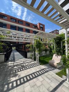 a white pergola in front of a building at WIDOKI3 Apartment Montownia Foodhall in Gdańsk