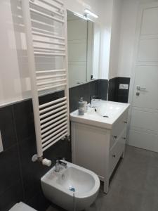 un bagno con lavandino, water e specchio di Viktoria's Suite Rome Center a Roma