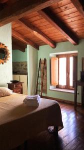 a bedroom with a bed and a ladder and a window at Is Antas in Orroli +13 photos