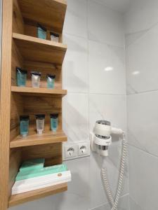 a bathroom with a phone and some cups on a shelf at Tukas Apartment in Marijampolė +11 photos
