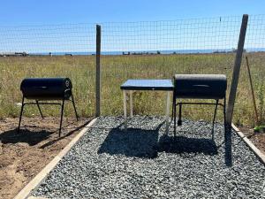 two chairs sitting at a table in front of a fence at La Corbu in Corbu