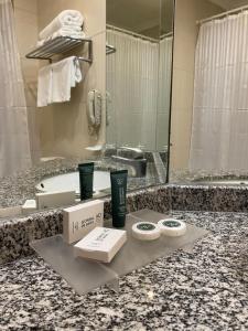 a bathroom with a counter with a sink and a tub at Hotel Diego de Almagro Aeropuerto in Santiago