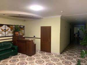 a living room with a green couch and a door at Готель "Український Дворик" in Lviv