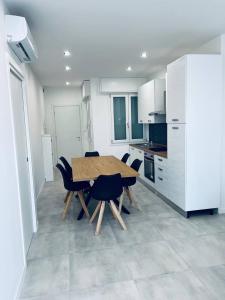 a kitchen with a wooden table and chairs at MK Apartments in Lido di Jesolo