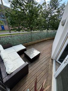 a patio with a couch and a table on a balcony at KM Granton Apartment in Edinburgh