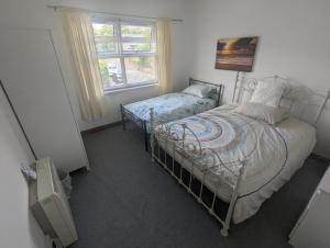 a bedroom with a twin bed and a window at The Apartment at Chalk House - 3 Beds - 1 Cot in Lindley