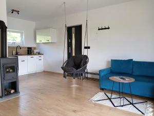 a living room with a blue couch and a stove at Domek I nad jeziorem OSTOJA Mrągowo-Krzywe mazury in Mrągowo