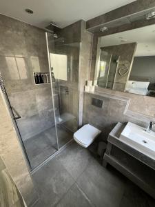 a bathroom with a shower and a toilet and a sink at KM Granton Apartment in Edinburgh
